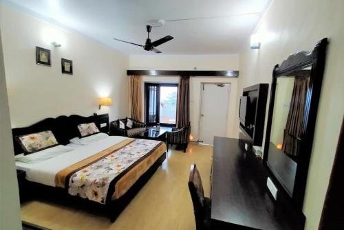 a bedroom with a large bed and a living room at Mountain resort view in Kausani