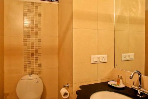 a bathroom with a toilet and a sink and a mirror at Mountain resort view in Kausani