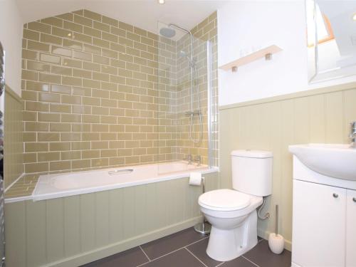 a bathroom with a tub and a toilet and a sink at 3 bed property in Winkleigh 66041 in Winkleigh