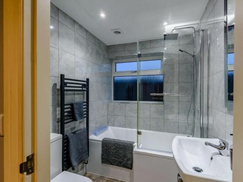 a bathroom with a tub and a sink and a shower at 3 bed in Hunmanby 66717 in Hunmanby
