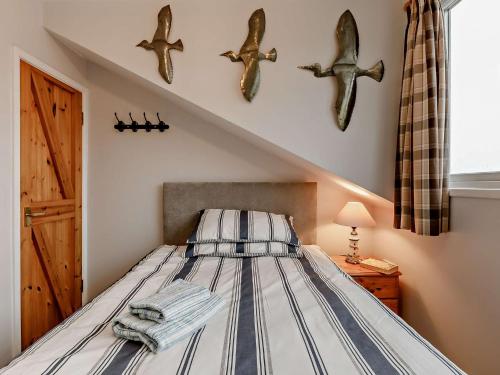 3 bed property in Brixham BX017 في بريكسهام: غرفة نوم مع سرير مع خطافات للأسماك على الحائط