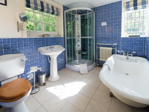 a blue tiled bathroom with a tub and a sink at 4 bed property in Knaresborough HH090 in Knaresborough
