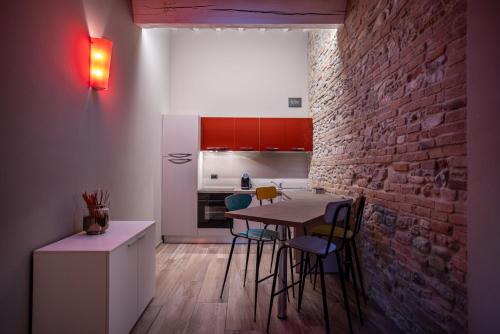 a kitchen with a table and chairs and a brick wall at Agriturismo La Ratta in Vernasca