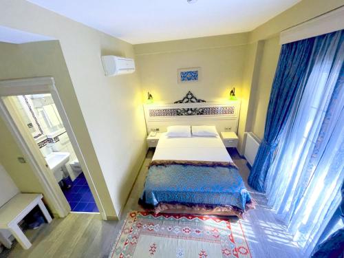 małą sypialnię z łóżkiem i umywalką w obiekcie Hotel Novano w Stambule