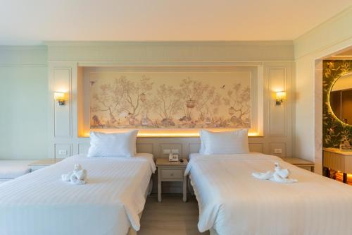 two beds in a hotel room with swans on them at The Hotspring Beach Resort & Spa - SHA Extra Plus in Natai Beach