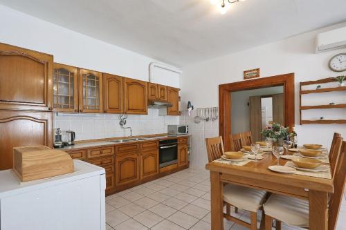 een keuken met houten kasten en een tafel met stoelen bij Seaview apartment Aida in Posedarje