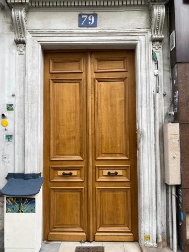 een grote houten deur met het nummer erop bij Appartement au coeur de Paris in Parijs