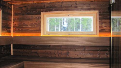 una ventana en una cabaña de madera con paredes de madera en villa julia, en Tampere