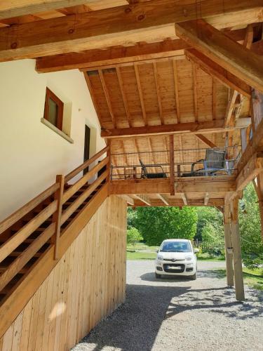 a house with a car parked in a driveway at WhispeRive Lodge - le vert aux bords de rive in Le Bourg-dʼOisans
