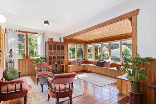 a large living room with wooden furniture and windows at Aranui palms - Mapua Holiday Home in Mapua