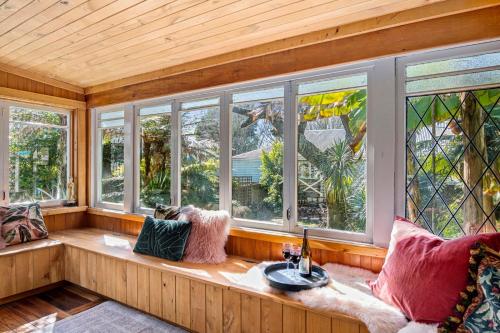 a room with windows and a couch with a sink at Aranui palms - Mapua Holiday Home in Mapua