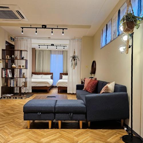 a living room with a blue couch and a bedroom at supiahouse in Tokyo