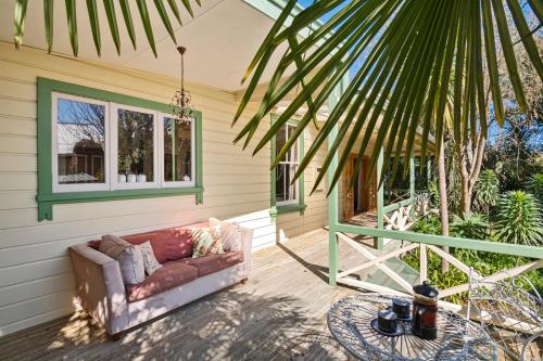 a couch sitting on the porch of a house at Aranui palms - Mapua Holiday Home in Mapua