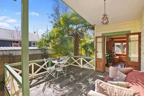 a porch with a couch and a table on a deck at Aranui palms - Mapua Holiday Home in Mapua