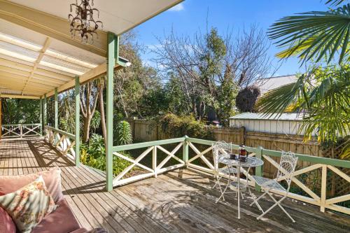 a wooden deck with a table and chairs on it at Aranui palms - Mapua Holiday Home in Mapua