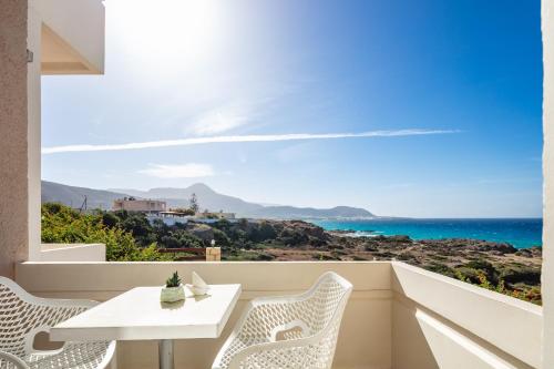a balcony with a table and chairs and the ocean at Falasarna Bay in Falasarna