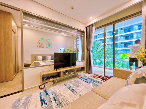 a living room with a tv and a large window at The Song WinHome Apartment in Vung Tau