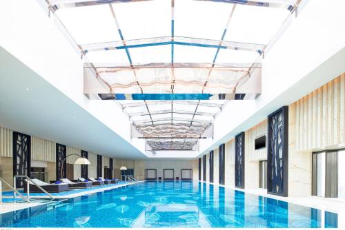 einem großen Pool in einem Gebäude mit einer Decke in der Unterkunft Sheraton Changde Wuling Hotel in Changde