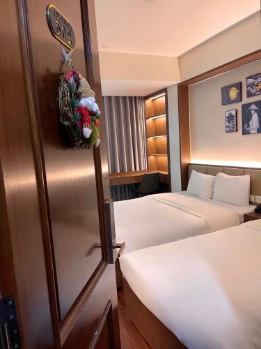 a hotel room with two beds and a sign on the wall at The Cosy Inn Hanoi in Hanoi