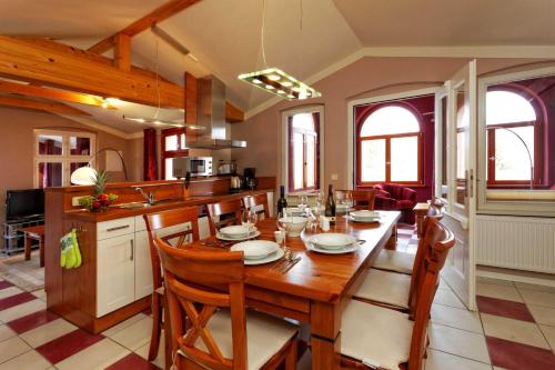kuchnia i jadalnia z drewnianym stołem i krzesłami w obiekcie Villa Maria Wohnung 09 w Koserowie