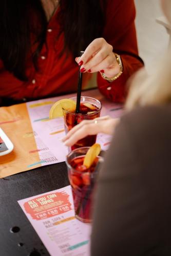 a woman sitting at a table with a drink at Van der Valk Theaterhotel Almelo in Almelo