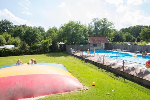 ein großer Swimmingpool mit Menschen im Hof in der Unterkunft Camping de Haer in Ootmarsum