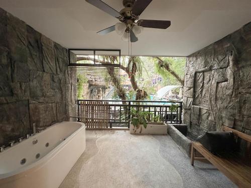 baño con bañera y ventilador de techo. en Phuvaree Resort, en Patong Beach
