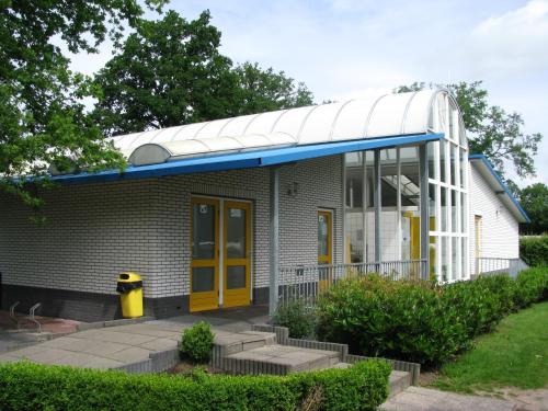 une petite maison blanche avec un toit bleu dans l'établissement Camping de Haer, à Ootmarsum