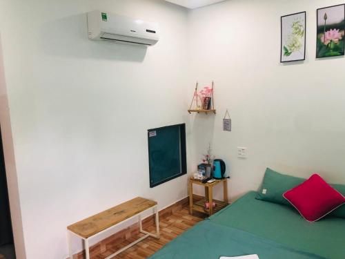 um quarto com uma cama verde e uma secretária em Như Ngọc Motel em Cà Mau