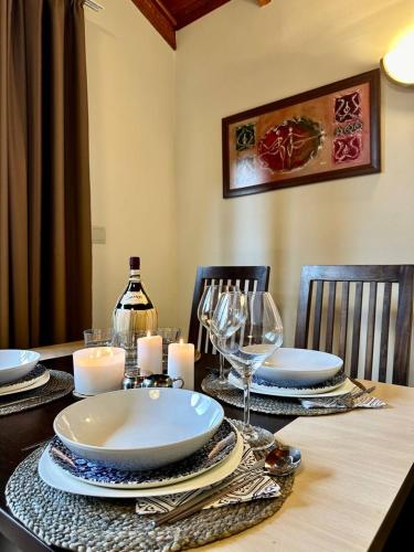 a dining room table with plates and glasses and candles at Spacious penthouse chalet apartment in Pirin Golf and Country Club in Razlog