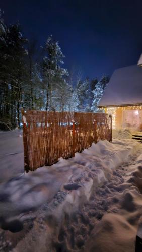 a fence covered in snow in front of a building at Kotula in AdamÃ³w