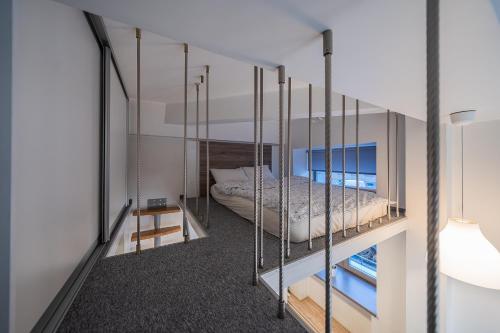 ヴィリニュスにあるKauno Loft - Lollo Luxuryのバルコニー付きの客室で、ベッド1台が備わります。