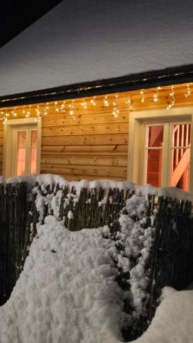 a house covered in snow with christmas lights on it at Kotula in AdamÃ³w