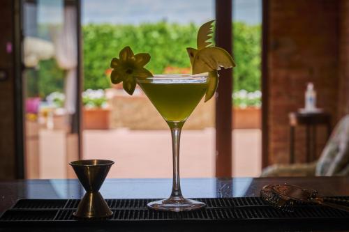 a drink in a martini glass on a table at Villa Curina Resort in Castelnuovo Berardenga