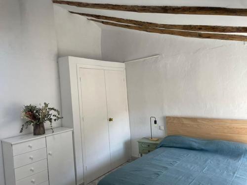 a bedroom with a bed and a white wall at La casita de la fuente in Cazorla