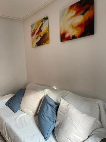 a white couch with two blue pillows on it at La casita de la fuente in Cazorla