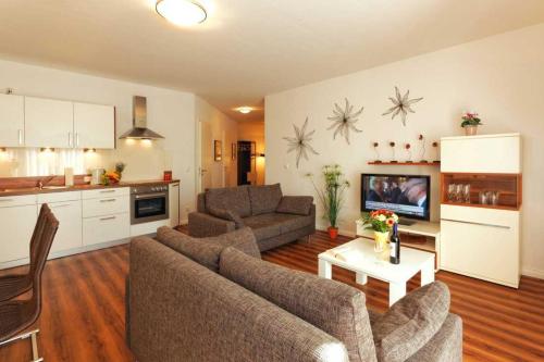 ein Wohnzimmer mit einem Sofa und einem Tisch sowie eine Küche in der Unterkunft Villa Marin Wohnung 21 in Zinnowitz