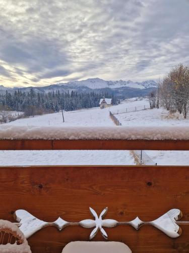 a view of a snow covered field from a balcony at Góralski Domek Łopatówka z kominkiem i Banią - Jacuzzi! in Murzasichle
