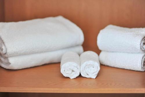 tre rotoli di asciugamani bianchi seduti su uno scaffale di Casa Algarvia a Pêra