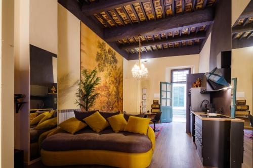 een woonkamer met een bank met gele kussens bij “Lo Scrigno” della Corte di Corso Cavour in Foligno