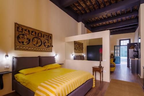 een slaapkamer met een bed met een geel dekbed bij “Lo Scrigno” della Corte di Corso Cavour in Foligno