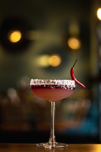 a cocktail in a glass with a red drink at The Kepos Hotel Erlangen in Erlangen