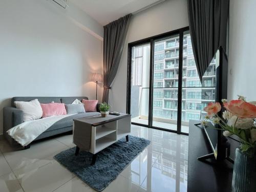 een woonkamer met een bank en een groot raam bij 3 Room Cozy Comfy 1-11 pax Old Klang Road 7 min to Midvalley in Kuala Lumpur