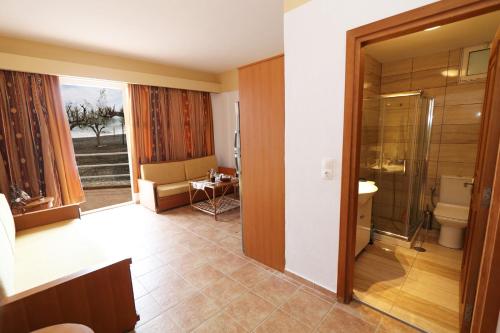 een badkamer met een douche, een toilet en een wastafel bij Tris Ekklisies Beachfront Apartment - Ammos in Paránimfoi