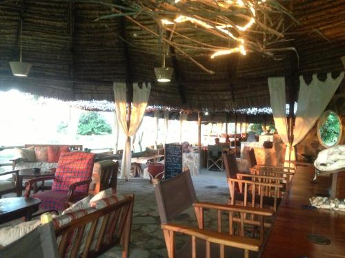 a room with chairs and tables and a dining room at Mikumi Wilderness Camp in Kikoboga