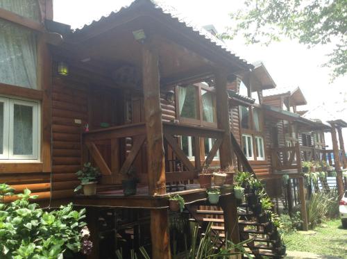 a large wooden cabin with a porch in the yard at Bunbury Fruit Ranch B&B in Renai