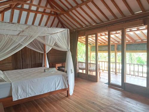 una camera da letto con un letto con zanzariera di Rumah Wayans Lipah ad Amed