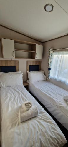 een slaapkamer met 2 bedden en een handdoek erop bij D4 Dove Close in Goodrington