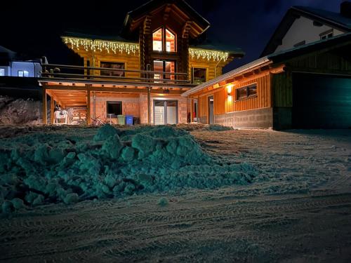 a house with a pile of snow in front of it at Ferienwohnung Uplandblockhaus in Willingen