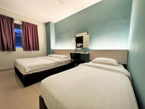 Habitación de hotel con 2 camas y lavamanos en De UPTOWN Hotel @ SS2, en Petaling Jaya